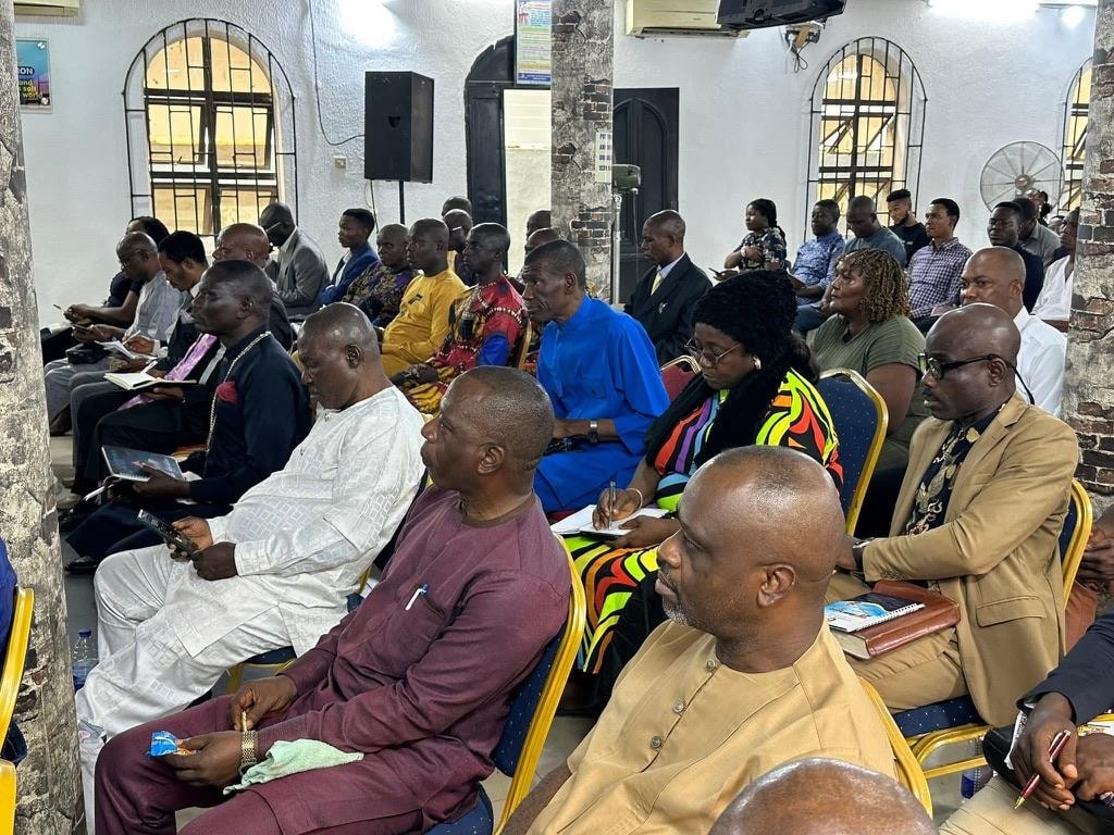 Ministers and members gathered attentively during a church service