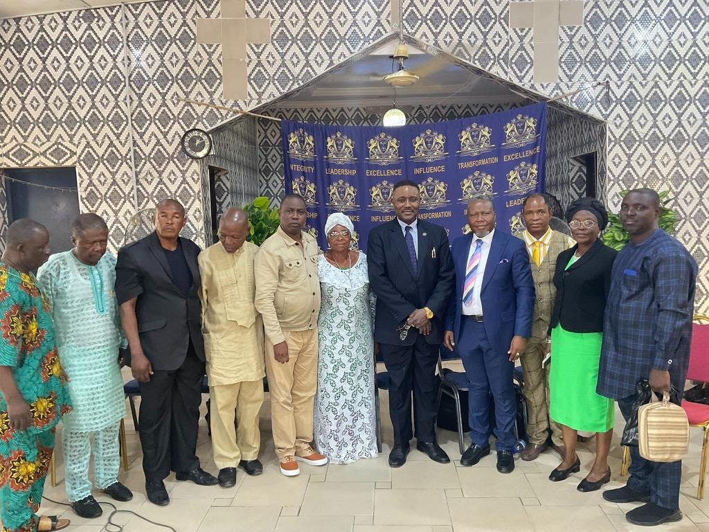 Leaders and ministers standing together in front of the Abraham University banner