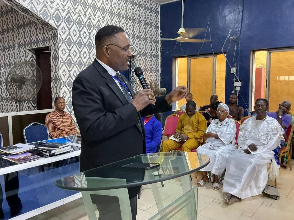 Apostle Abraham preaching at the pulpit to a gathered congregation